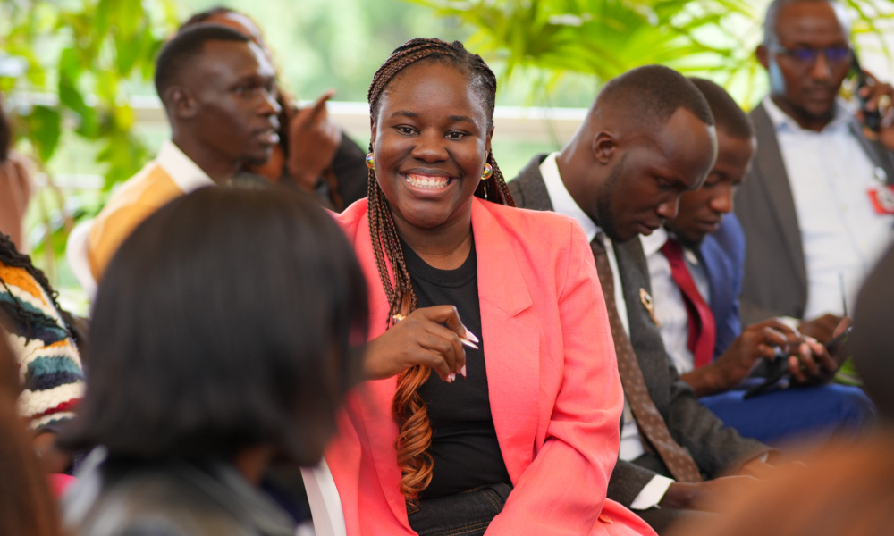 A woman smiles and speaks to someone sitting next to her during an event