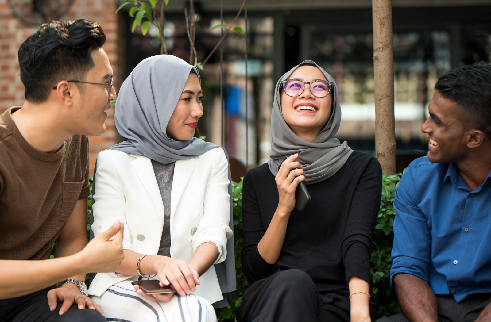 Four young people from Asia sit together in a group