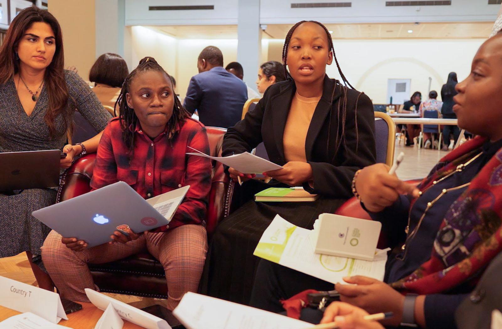Four young people sit in a group during a brainstorm session