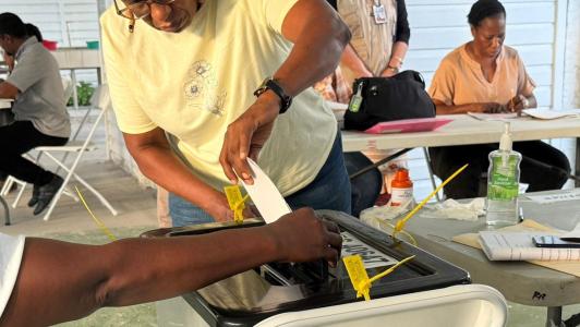 woman casting a vote at a polling station in Guyana