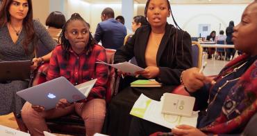 Four young people sit in a group during a brainstorm session