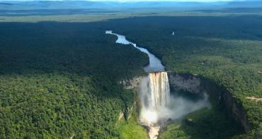 Aerial view of a waterfall surrounded by forest in Guyana